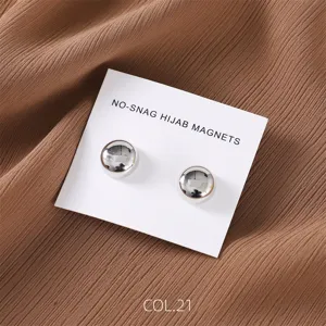 Detailed shot of round silver magnetic hijab pins on display card, smooth finish accessory.