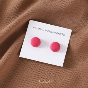 Matte pink magnetic hijab pin detail, secure round scarf magnet accessory close up view.