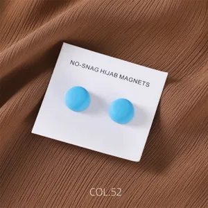Close-up detail of matte blue magnetic hijab pins on display card, elegant scarf accessory.