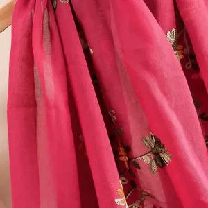 Close-up detail of lightweight cotton linen embroidered scarf floral pattern pink shawl fabric.
