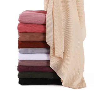 Vista dettagliata di scialle in chiffon plissettato con punti argentati scintillanti e vari.