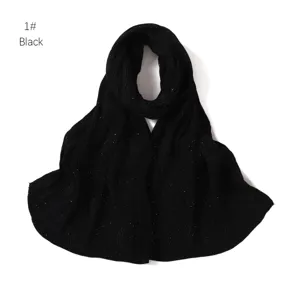 Dettaglio di sciarpa in chiffon plissettato nero, con glitter argento, morbida.