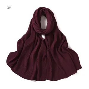 Dettagli della sciarpa hijab in chiffon plissettato luccicante, con texture glitterata ravvicinata.