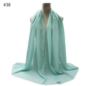 Close-up detail of the lightweight mint green pearl chiffon hijab and scarf fabric texture.