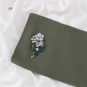 Olive green chiffon scarf detail featuring handmade rhinestone floral and dragonfly embellishment.