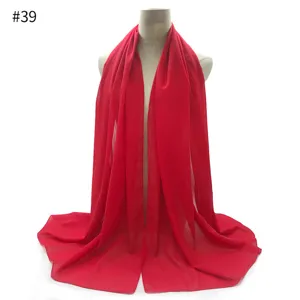 Red chiffon scarf detail view, lightweight bubble fabric, elegant draped shawl texture.
