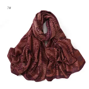 Detailed view of the pleated gold foil leaf scarf, lightweight breathable fabric close up.
