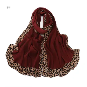 Gros plan d'un foulard plissé bordeaux avec bordure tendance à motif de léopard.
