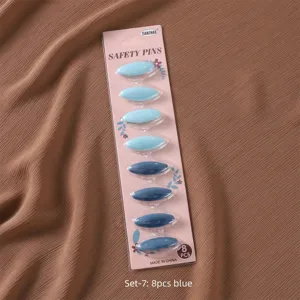 Detailed view of colorful plastic safety pins in blue shades, 8 pieces carded pack.