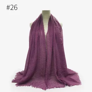 Dettaglio della sciarpa hijab viola stropicciata, tessuto morbido con bordi sfrangiati.