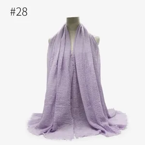 Primo piano texture sciarpa hijab stropicciata in cotone TR viola chiaro con dettaglio bordo frange.