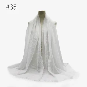 Primo piano della sciarpa stropicciata in cotone TR bianco con dettagli di frange.