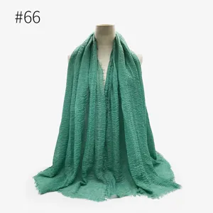Vista dettagliata del foulard stropicciato verde, trama di tessuto scialle con frange.