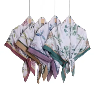 Elegant floral printed wavy edge large square scarf and wrap shawl hanging on hangers.