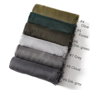 Detailed view of rolled modal cotton scarves with short fringes in various stylish solid colors.