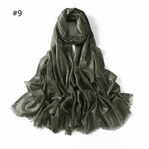 Close-up detail of the dark green shimmering viscose scarf showing metallic threads and fringe.