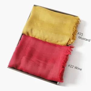 Close-up detail of modal cotton solid color fringe scarf in mustard and wine red colors.