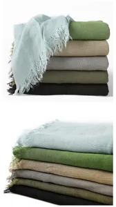 Gros plan de foulards en rayonne douce avec texture froissée et franges effilochées.