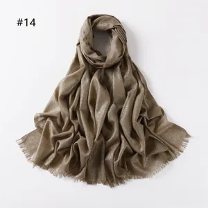 Detailed view of the shimmering metallic viscose scarf with short fringe ends in elegant gold.