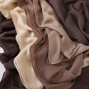 Gros plan détaillé de ce tissu foulard modal souple, texture respirante et nuances marron.