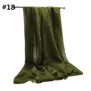 Vista detallada de la bufanda de viscosa verde oliva con brillo dorado y textura suave.