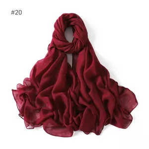 Close-up detail of a dark red glitter viscose cotton linen scarf draped elegantly on display.