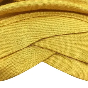 Close-up detail shot of yellow modal stretchy cross-front turban cap showing soft knit texture.