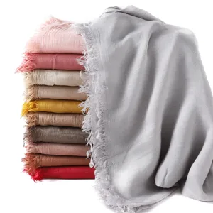 Detailed view of colorful solid color cotton modal fringe scarves and breathable shawls.