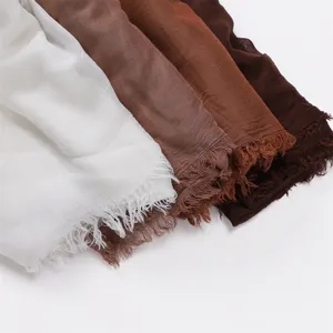 Close-up detail view of soft modal cotton blend scarves featuring delicate frayed edges and colors.