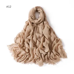 Detail view of lightweight modal cotton scarf texture with fringe tassels in solid beige color.