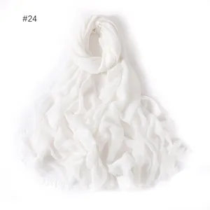 Detail view of the lightweight solid white modal cotton scarf featuring delicate short fringe edges.