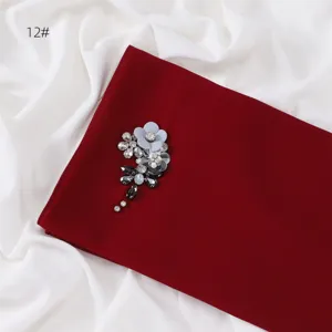 Exquisite handmade rhinestone flower chiffon scarf detail shot, elegant dark red fabric.