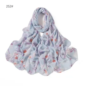Vista dettagliata della sciarpa in chiffon floreale azzurro, tessuto leggero e design elegante.