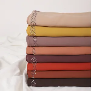 Detailed view of multi-color chiffon headscarf with rhinestone embellishments, stacked neatly.