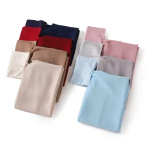 Close-up detail showing assorted solid color chiffon headscarves and tube caps set, soft fabric texture.