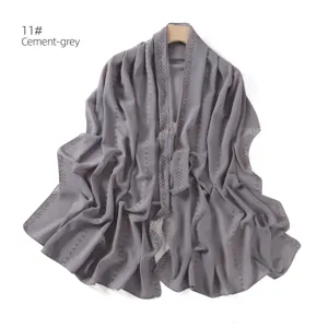 Grey chiffon scarf detail showcasing sparkling rhinestone striped design and fine texture.