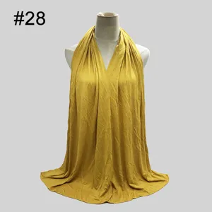 Detailed view of yellow solid color modal hijab scarf draped gracefully on mannequin.
