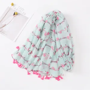 Close-up detail of the mint green flamingo printed scarf featuring handmade pink tassels.