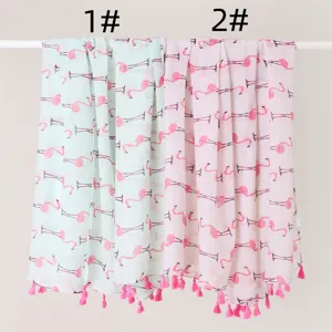 Close-up detail of lightweight flamingo print scarf with pink tassels, elegant design.