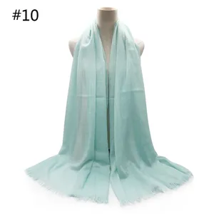 Mint green breathable cotton scarf detail, featuring delicate tassel fringe and soft fabric texture.