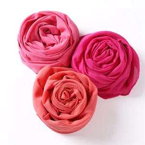 Detailansicht eines einfarbigen Chiffon Kopftuchs als Rose gerollt, weicher Stoff.