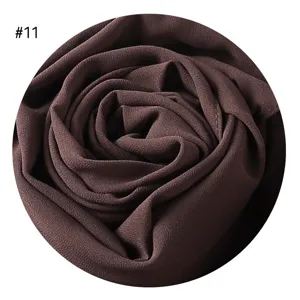 Detaillierte Nahansicht des dunkelbraunen strukturierten Chiffon-Schal-Stoffswatches.
