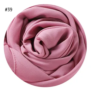 Detailaufnahme eines rosafarbenen Chiffon-Hijab-Schals mit feiner Blasentextur und Rolle.