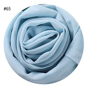 Detailaufnahme von hellblauem Chiffon-Schalstoff, elegant als Rosenform gerollt.