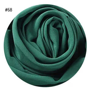 Dunkelgrüner Perlen-Chiffon Hijab Stoff Detail mit weicher Textur und unifarbenem Design.