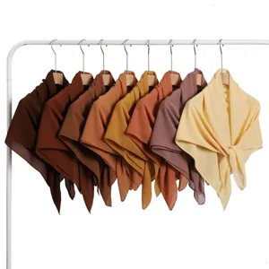 Detail view of multi-color chiffon square scarves hanging in gradient tones on a white rack.