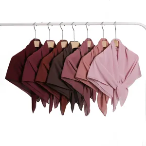 Solid color chiffon square scarf detail showing multiple gradient shades hanging neatly on rack.