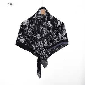 Close-up view of the black and white floral printed pleated chiffon scarf fabric and texture.