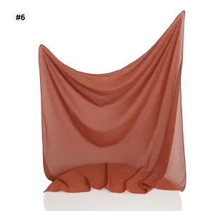 Detailansicht des leichten Chiffonkopftuchs mit filigranen Strass-Schleifen und Perlendetails.