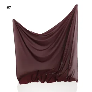 Detailaufnahme des leichten Chiffon-Quadratstuchs mit Strass-Schleife und Perlen.